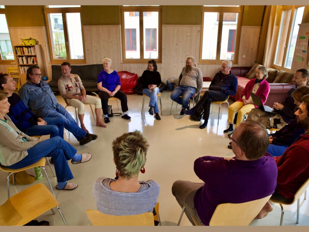 Menschen sitzen im Kreis und sprechen miteinander